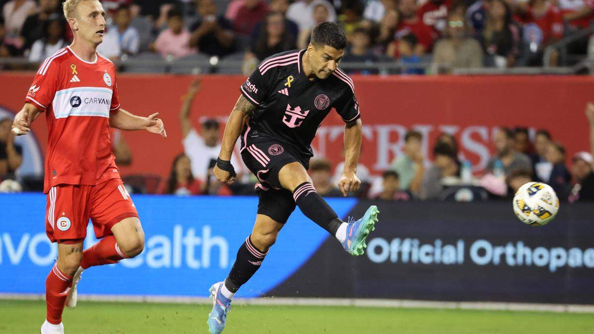 Aug 31, 2024; Chicago, Illinois, USA; Inter Miami CF forward Luis Suarez (9) shoots and scores a goal against Chicago Fire FC defender Tobias Salquist (14) in the second half at Soldier Field. Mandatory Credit: Mike Dinovo-USA TODAY Sports