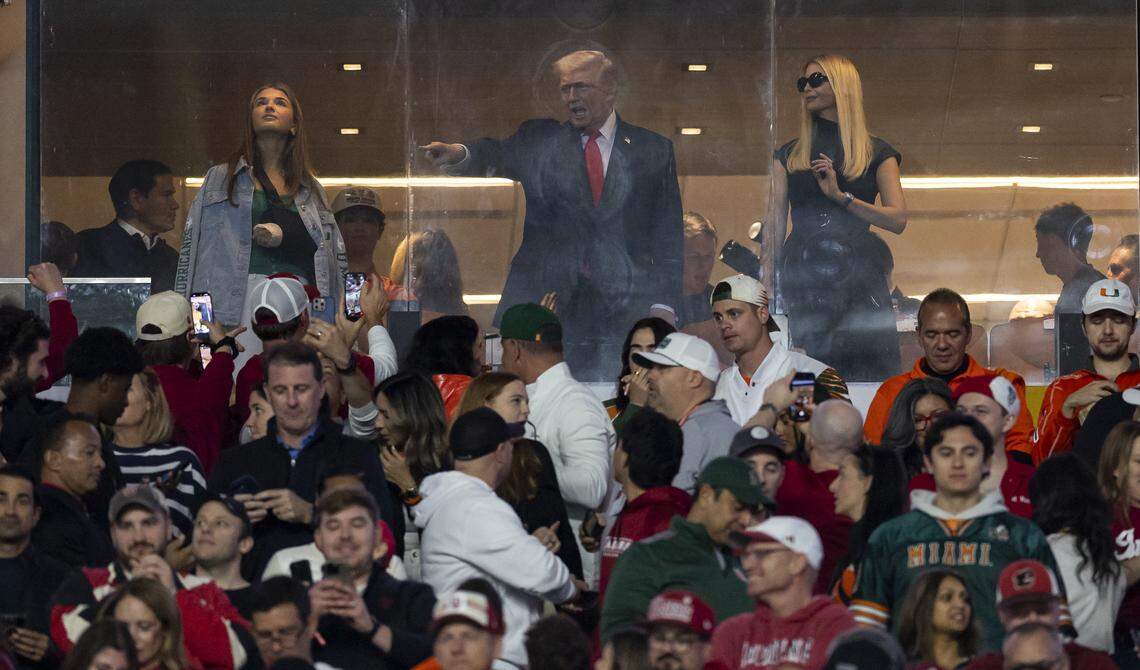President Donald Trump points toward the crowd before the start of the College Football Playoff National Championship Game between the Miami Hurricanes and Indiana Hoosiers at Hard Rock Stadium on Monday, Jan. 19, 2026, in Miami Gardens, Fla.