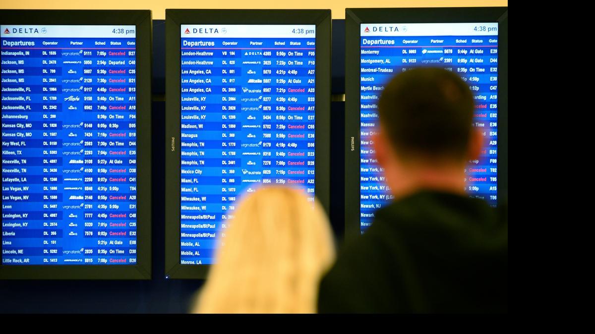 
In this Feb. 25, 2015 photo, airline passengers look at departure screens with flight cancellations posted as a winter storm bringing a mix of snow, sleet and rain resulted in an FAA-ordered ground stop at Hartsfield-Jackson International Airport in Atlanta. 

