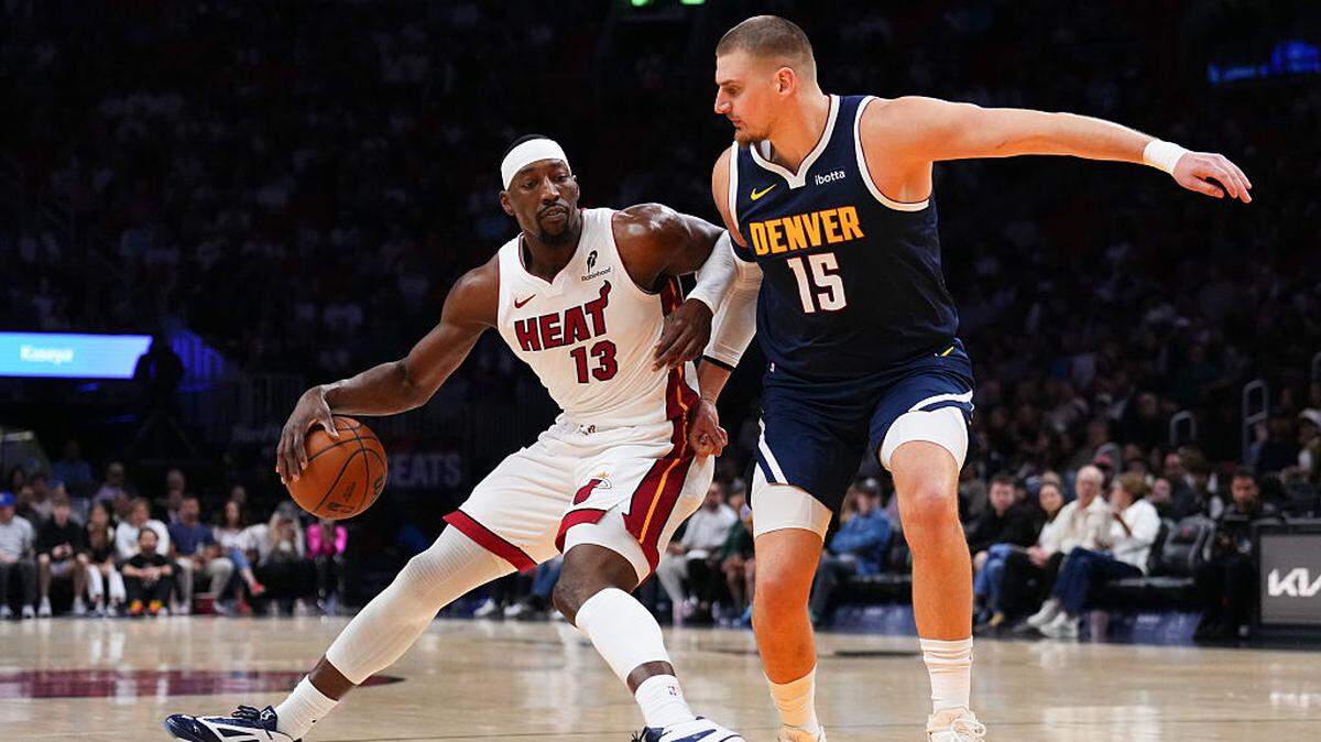 Bam Adebayo #13 of the Miami Heat dribbles the ball against Nikola Jokic #15 of the Denver Nuggets during the first quarter at Kaseya Center on December 29, 2025 in Miami.