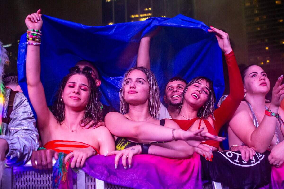 Festival goers attempt to stay dry as they dance to the music during Ultra 2024 at Bayfront Park in Downtown Miami on Friday, March 22, 2024.