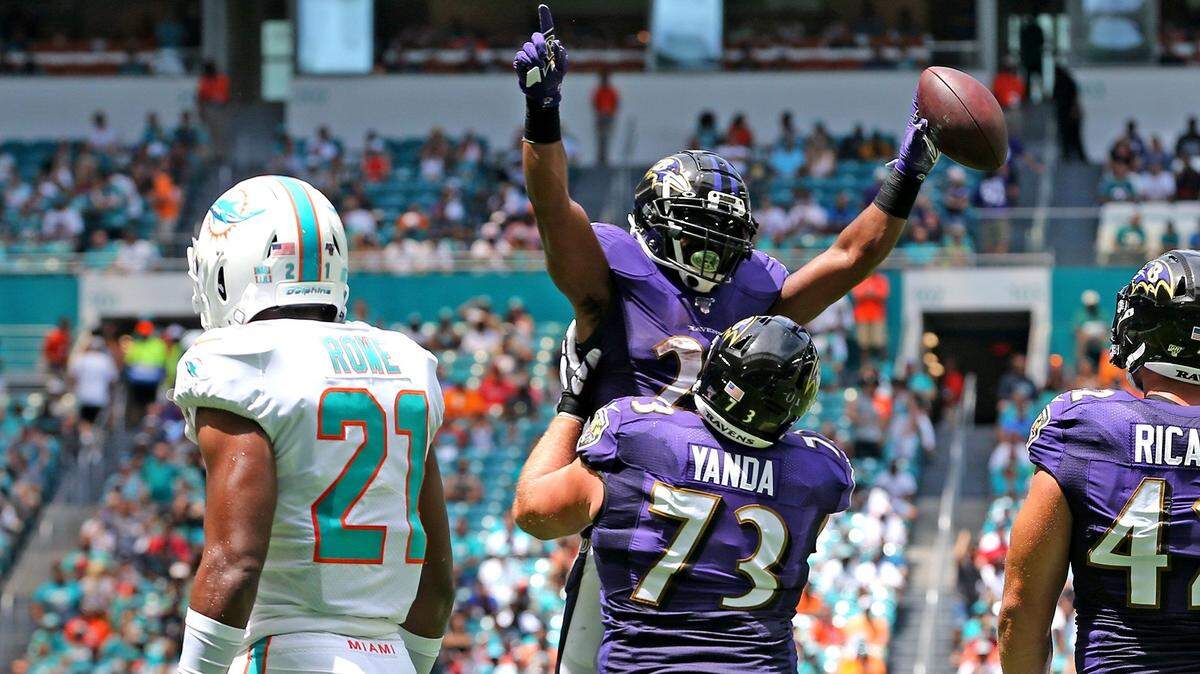 Miami Dolphins cornerback Eric Rowe (21) watches as Baltimore Ravens Marshal Yanda (73) lifts Mark Ingram (21) after Ingram’s touchdown in the first quarter at Hard Rock Stadium in Miami Gardens, Florida, Sunday, September, 8, 2019.
