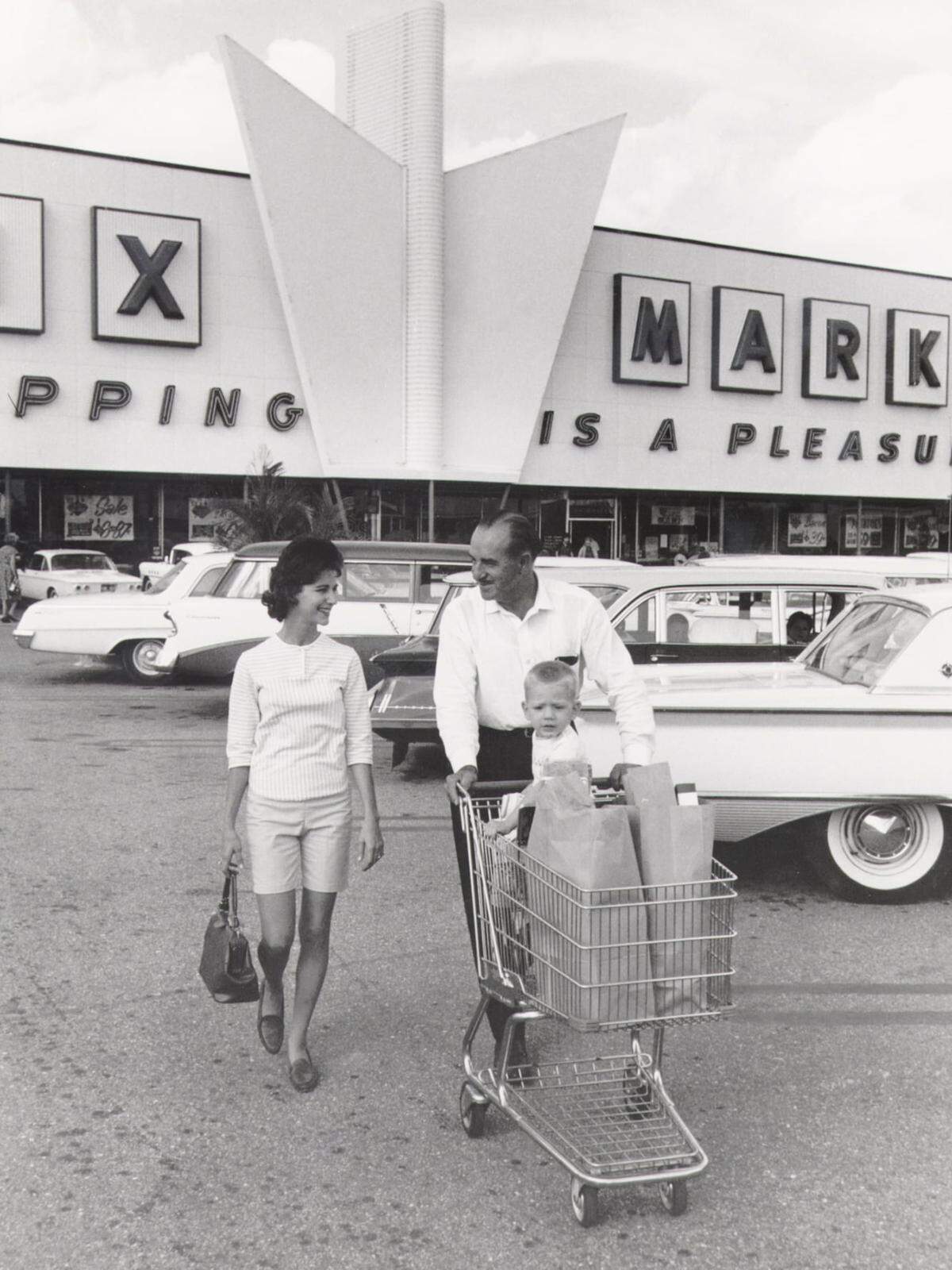 Publix founder George Jenkins takes a customer’s grocery bags to her car in this undated photo.