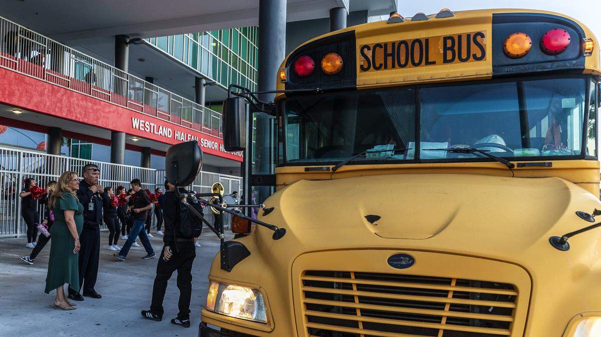 Staff members welcomed students arriving by bus at Westland Hialeah Senior High School during the first day of school for Miami-Dade County Public Schools on Aug. 14, 2025.