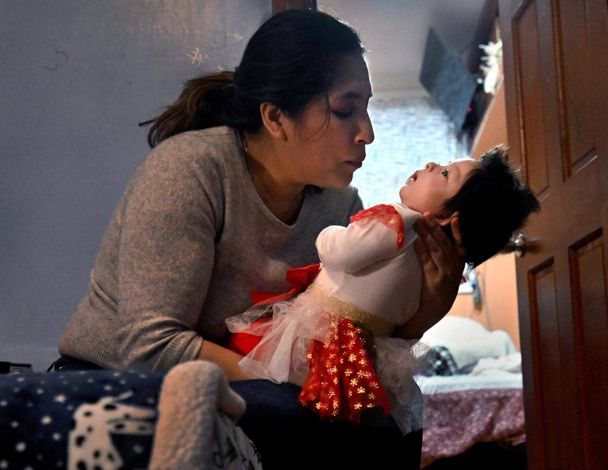 Jessica Supliguicha cradles her baby Cristina at their apartment in Queens, New York, on Dec. 18, 2025.  Jessica was eight months pregnant when her husband Jorge was detained by ICE in September at the Jacob Javits Federal Building in New York. He was deported to Ecuador three days before the baby was born.