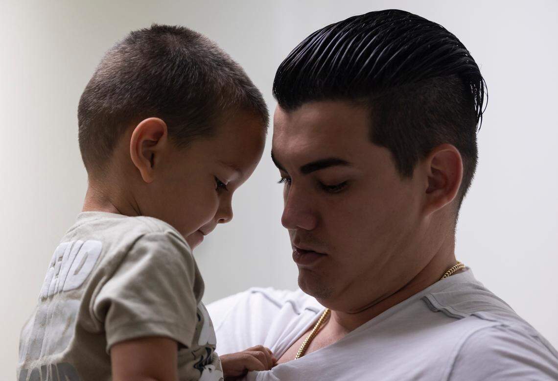 Brayan Soto, 26, holds his son Jeison Soto, 3, in a hallway at the Miami immigration court in downtown Miami.