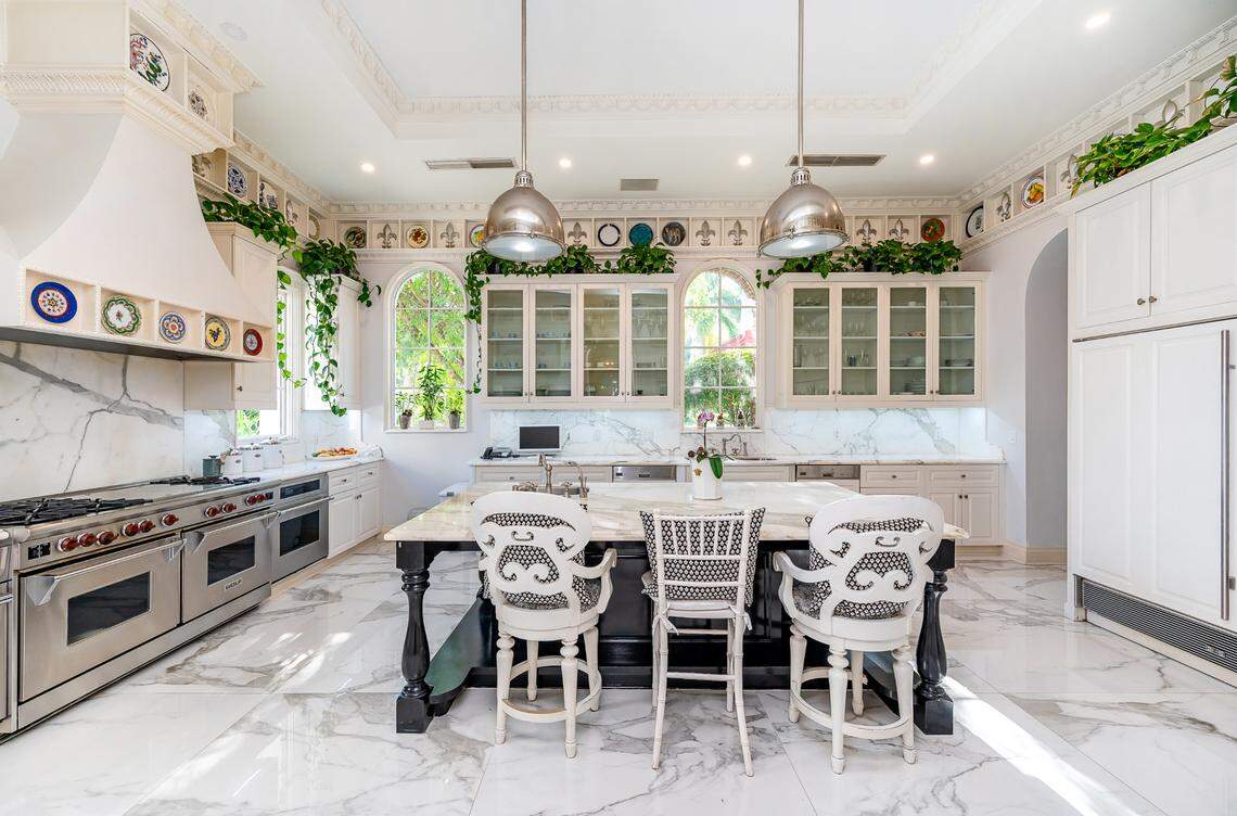 The Alarcón home features a gourmet kitchen, pictured above, with double gas ovens and stoves, marble floors and countertops, and adjacent breakfast room.