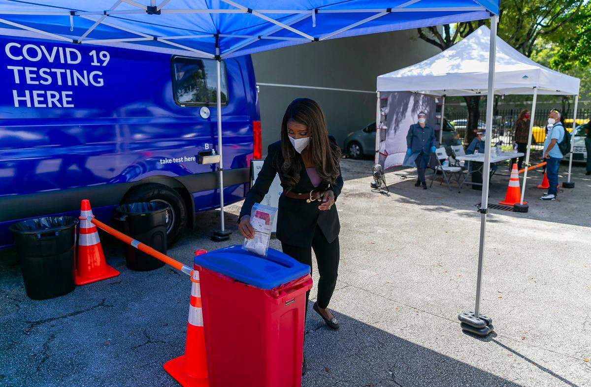 Symeria Hudson, the president and CEO of Chapman Partnership, turns in her swab kit after taking a Curative COVID-19 PCR test at the nonprofit’s parking lot in Miami on Tuesday, Oct. 5, 2021.