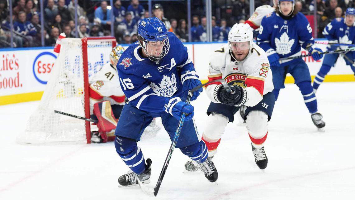 Nov 28, 2023; Toronto, Ontario, CAN; Toronto Maple Leafs right wing Mitchell Marner (16) battles for the puck with Florida Panthers defenseman Dmitry Kulikov (7) during the third period at Scotiabank Arena.