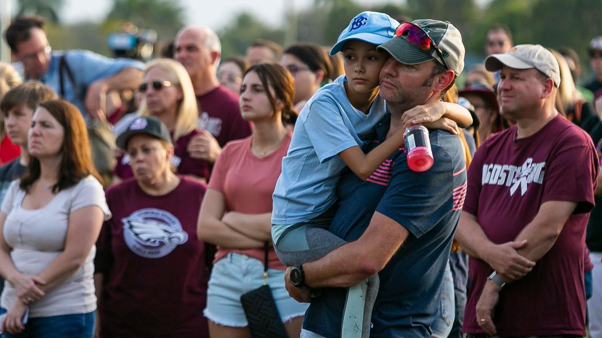Michael Glenn, and his daughter, Taina Glenn, 10, attend an interfaith ceremony to remember the 17 victims killed at the Marjory Stoneman Douglas High School shooting on the two-year anniversary in Parkland, Florida on Friday, February 14, 2020.