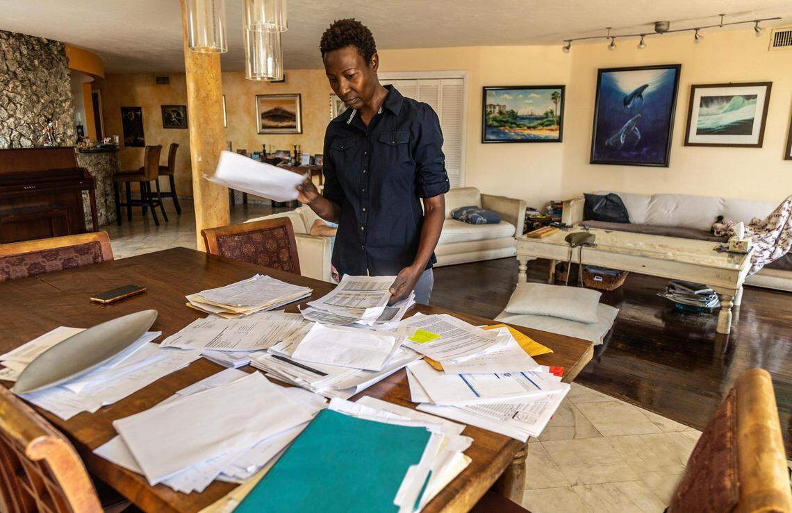 Sipiwe Anderson looks at paperwork on June 10 related to her condo at 8125 Crespi Blvd. Anderson is struggling to keep up with more than $100,000 in special assessments imposed by the owner of three units in the building.