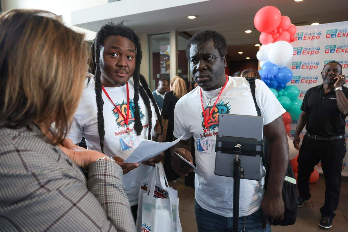 1GR Urbanwear CEO and Owner Jovany Appolon, left, and business partner Bazile Bourdeau, right, speak to City of North Miami Development Services Director Debbie Love during the City of North Miami District 4 Small Business Expo at the Joe Celestin Center at 1525 NW 135th St. in North Miami, Florida, Friday, August 22, 2025.