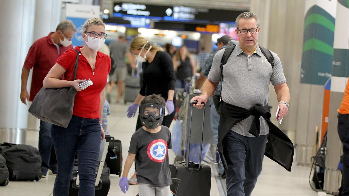 ARCHIVO: Pasajeros en el Aeropuerto Internacional de Miami usan máscaras para protegerse del coronavirus. El Departamento de Estado levantó su recomendación de evitar viajes al extranjero por el coronavirus.
