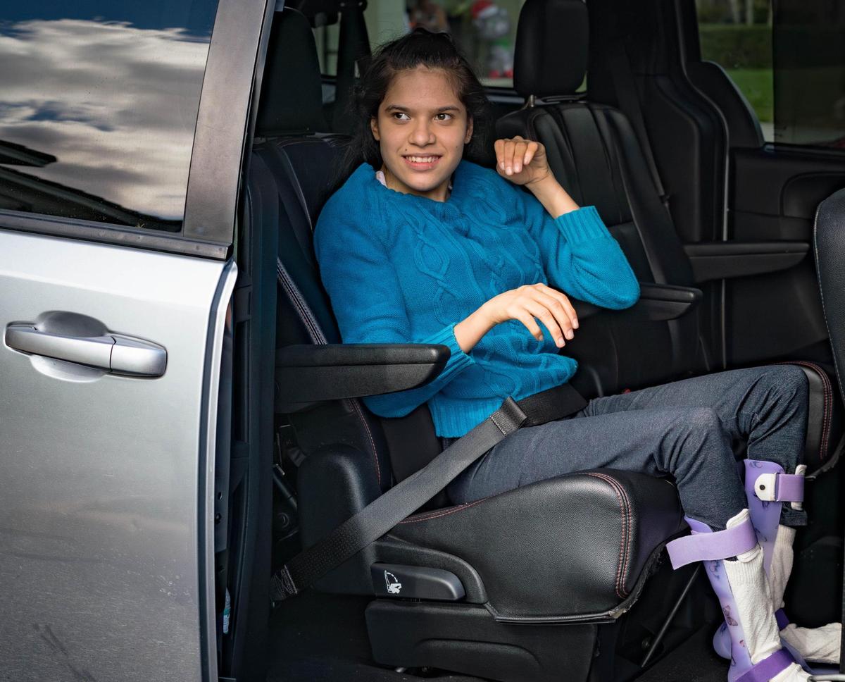 Standarlyn Muñoz Delgado, 20, smiles after being seated in the car. Muñoz Delgado can’t speak but expresses her love for car rides through her gesture.