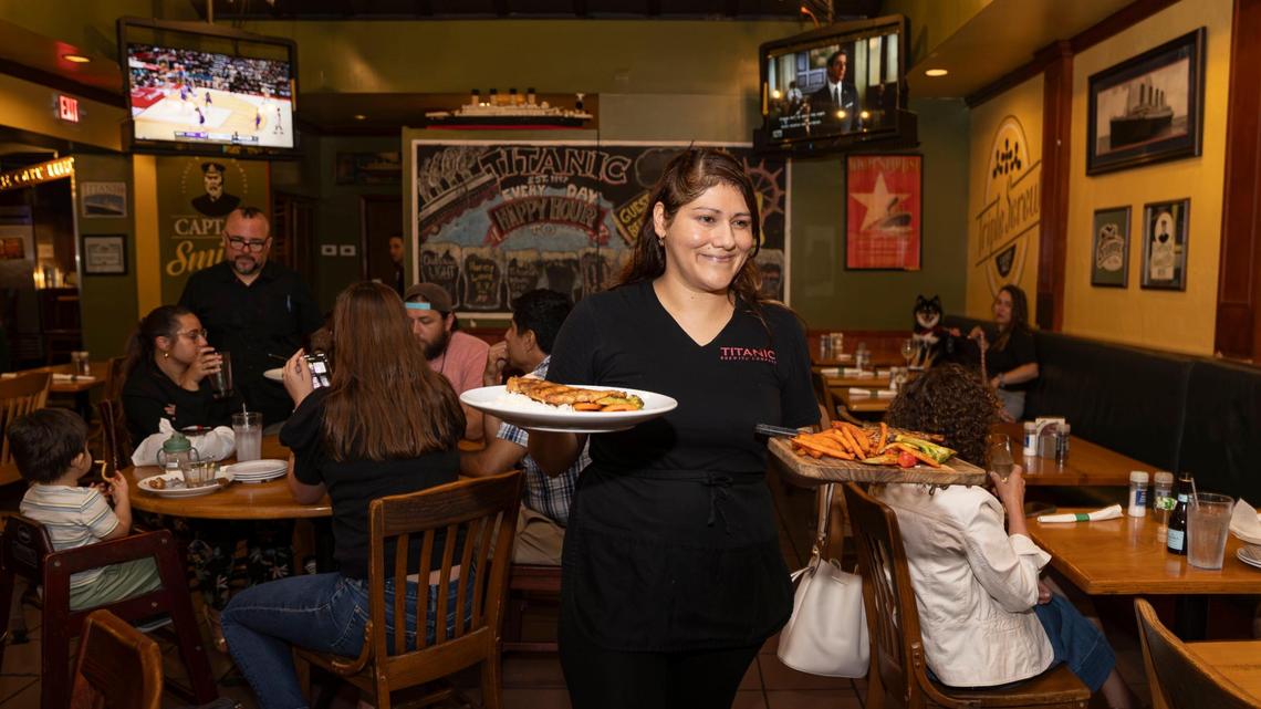 Jazmin Robles, server and brand manager at Titanic Brewery, serves customers the Korean salmon special and pork chop with sweet potatoes.