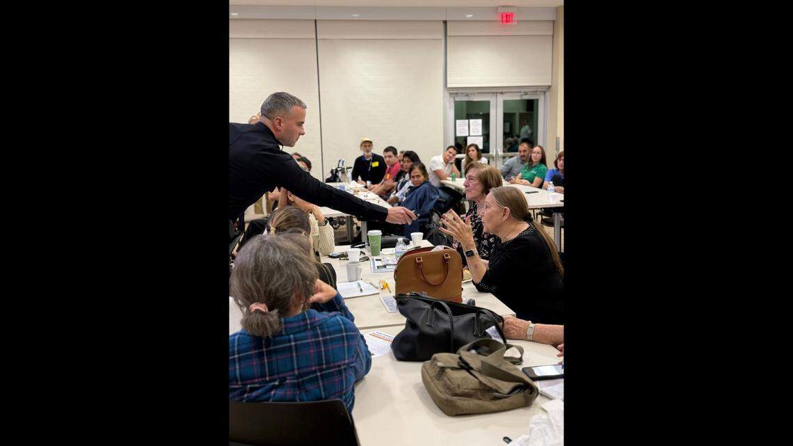 Miami Springs Police Chief Matthew Castillo listens as a resident expresses concerns about improper teen behavior she has observed downtown.