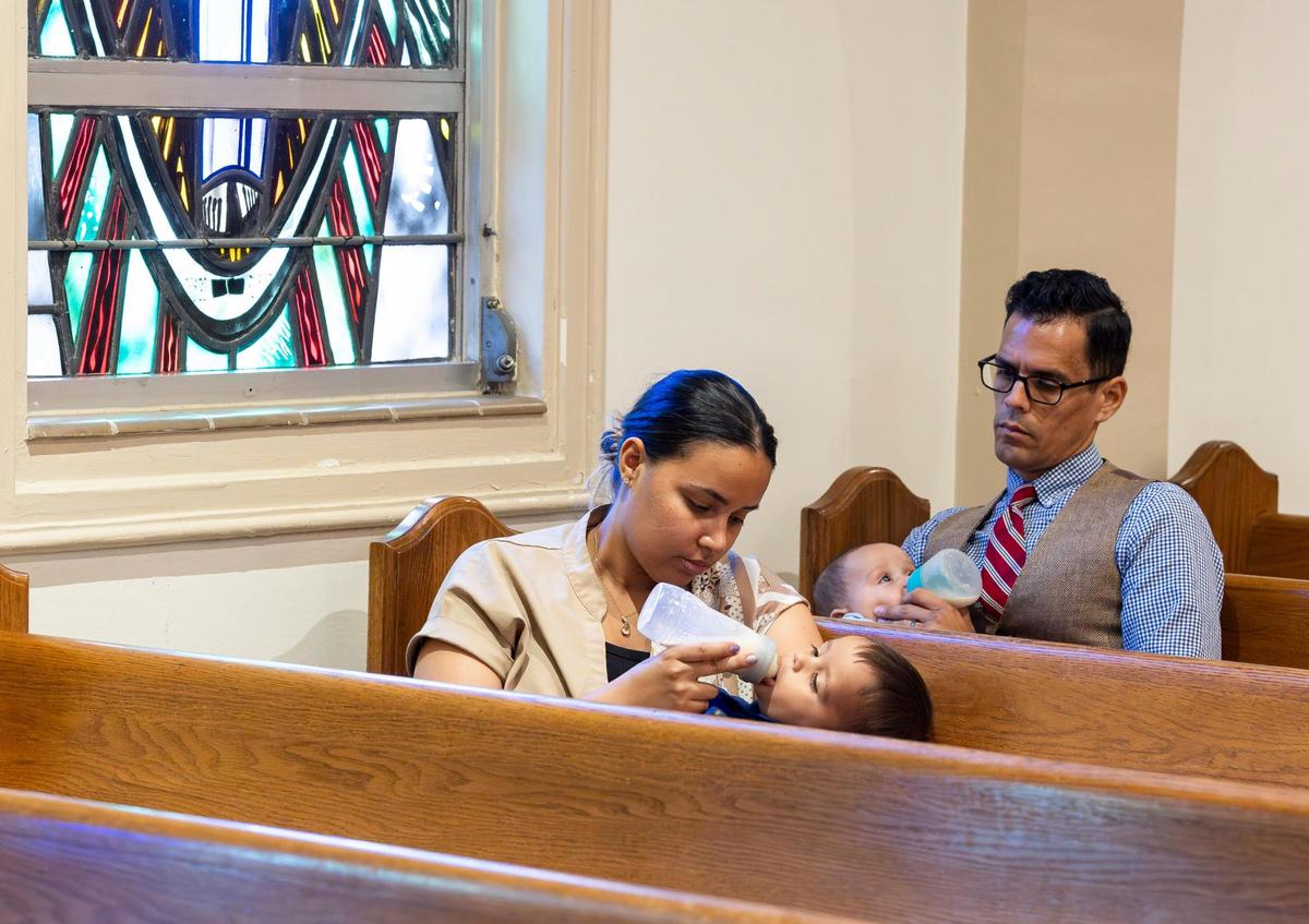 John Vargas and his wife, Daisy Vargas, feed their son Charbel, 1, left, and their 4-month-old daughter, Maria Caterina, as they attend a Good Friday service at the Cathedral of St. Mary on Friday, April 18, 2025, in Miami, Fla.