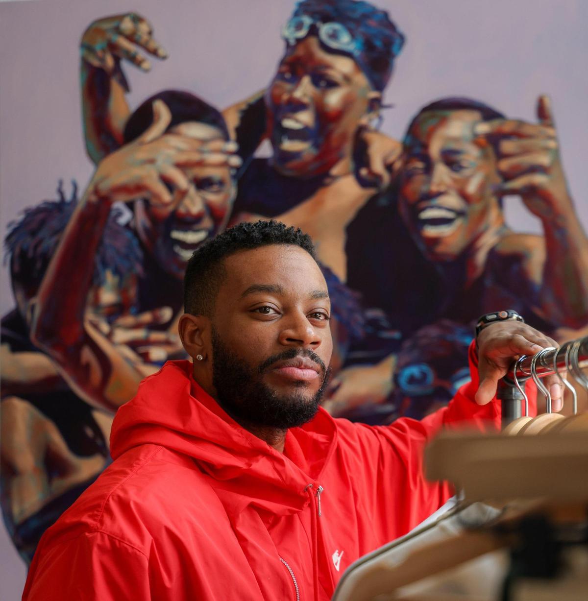 Artist Anthony “Mojo” Reed II is photographed at Grand Opening Gallery. In the background is one of his pieces entitled “OVERtown: The Brothahood.”