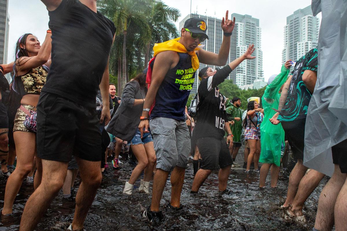 People dance in the rain during Ultra 2024 at Bayfront Park in Downtown Miami on Friday, March 22, 2024.
