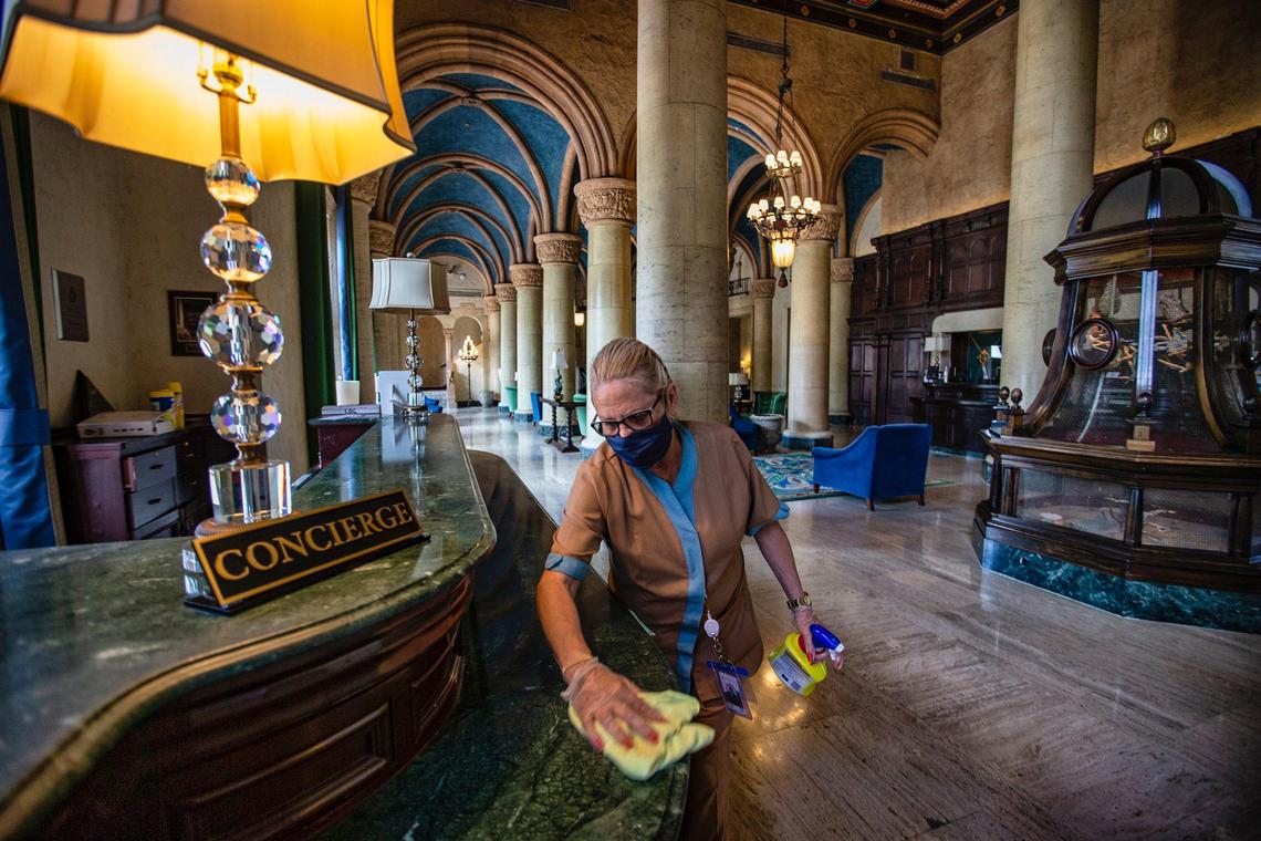 The Biltmore Hotel’s guest room attendant Hilda Castillo, 62, disinfects the concierge area of the hotel lobby in advance of its June 1, 2020, opening.