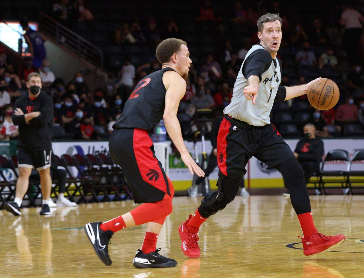 Toronto Raptors guard Goran Dragic, right, controls the ball during an NBA basketball team scrimmage in London, Ontario, Saturday, Oct. 2, 2021.