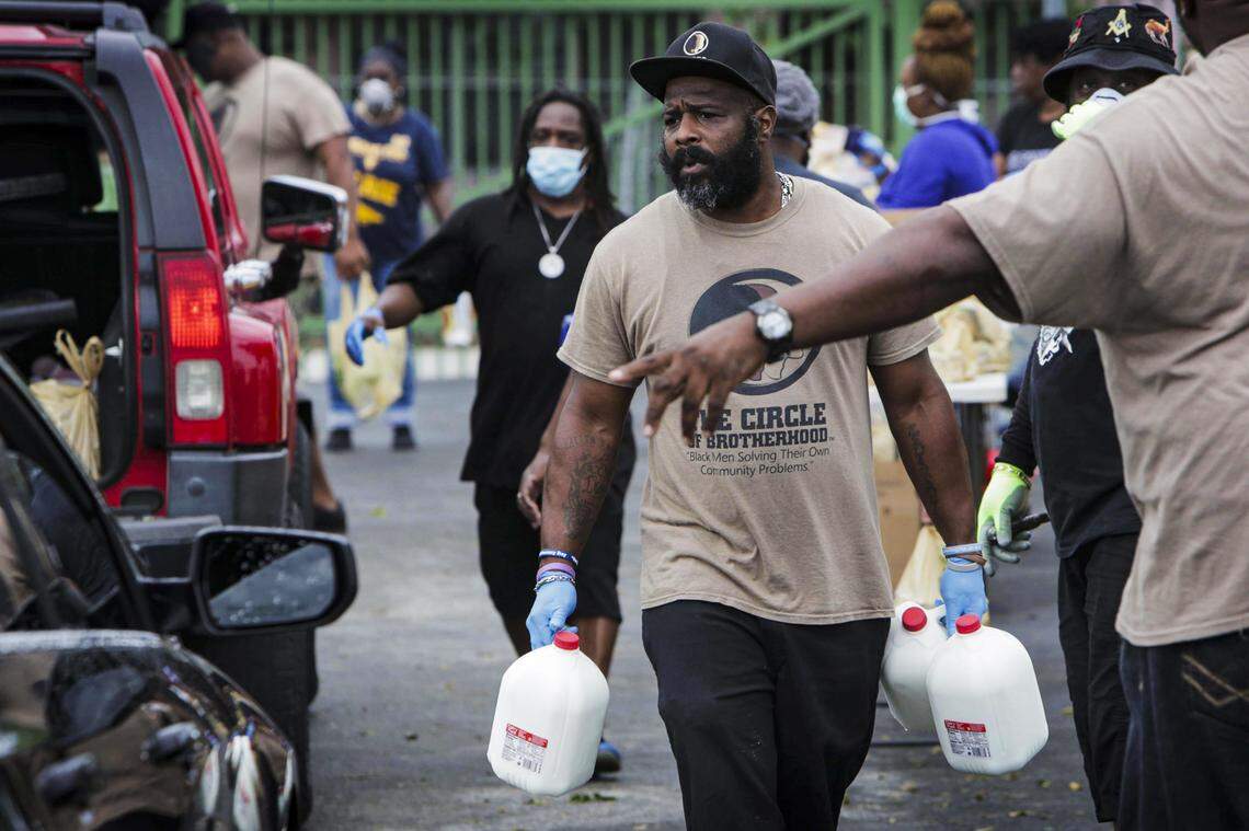 Volunteers hurry to fill the trunks of those who came to a food donation drive at 6100 NW Second Ave. in Miami on April 1, 2020. Elliott’s Ark of the City nonprofit partnered with the food rescue nonprofit Farm Share to get donated groceries to people in need during the coronavirus pandemic via drive-through drop-offs.