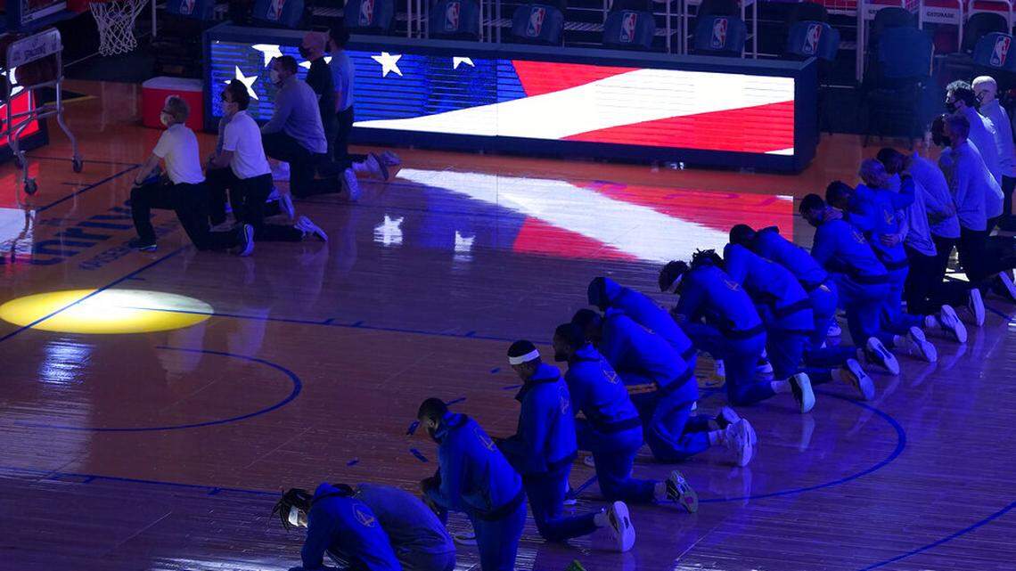 Golden State Warriors players and coaches kneel during the national anthem before an NBA basketball game against the Los Angeles Clippers in San Francisco, Wednesday, Jan. 6, 2021. (AP Photo/Jeff Chiu)