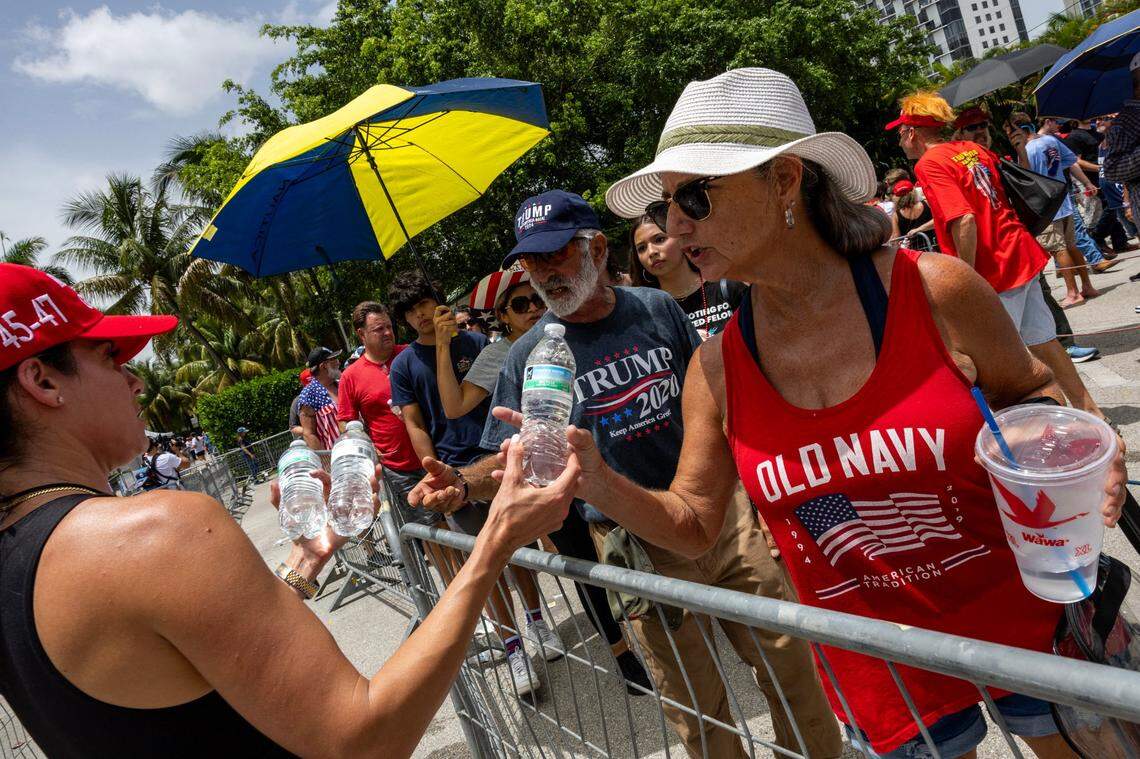 Volunteers hand out water to Trump supporters as they enter before the start of a rally at Trump National on Tuesday, July 9, 2024, in Doral, Fla.