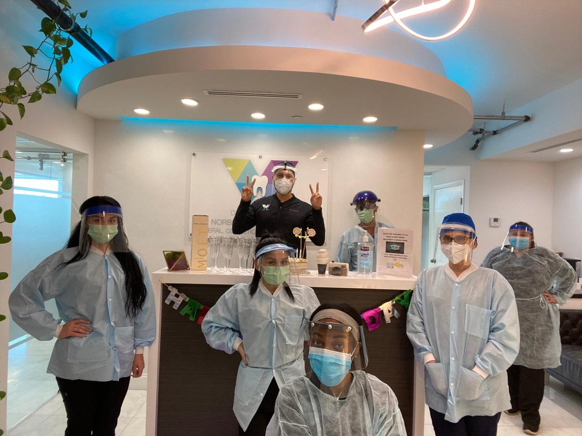 Dr. Norberto Camacho, center, a 35-year-old dentist at Dental World Miami in Brickell poses in full protective equipment with his staff, from left, Zaria Figueredo, Gabriela Rivas, Jose D. Contreras, Blanca R. Camacho, Aracely Gonzalez, Mesha Gilmore and Sandra Caceres.