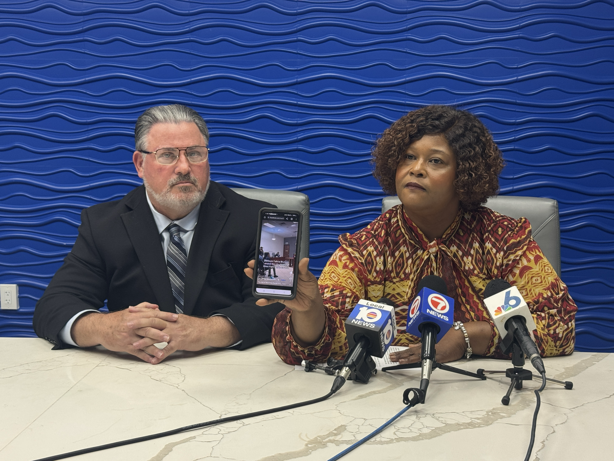 West Park City Commissioner Katrina Touchstone shows reporters at a press conference on Aug. 22 a video of a chaotic city commission meeting in which Mayor Felicia Brunson adjourned early. Touchstone and her attorney Michael Pizzi are suing the city, the mayor, the city clerk and the city manager.