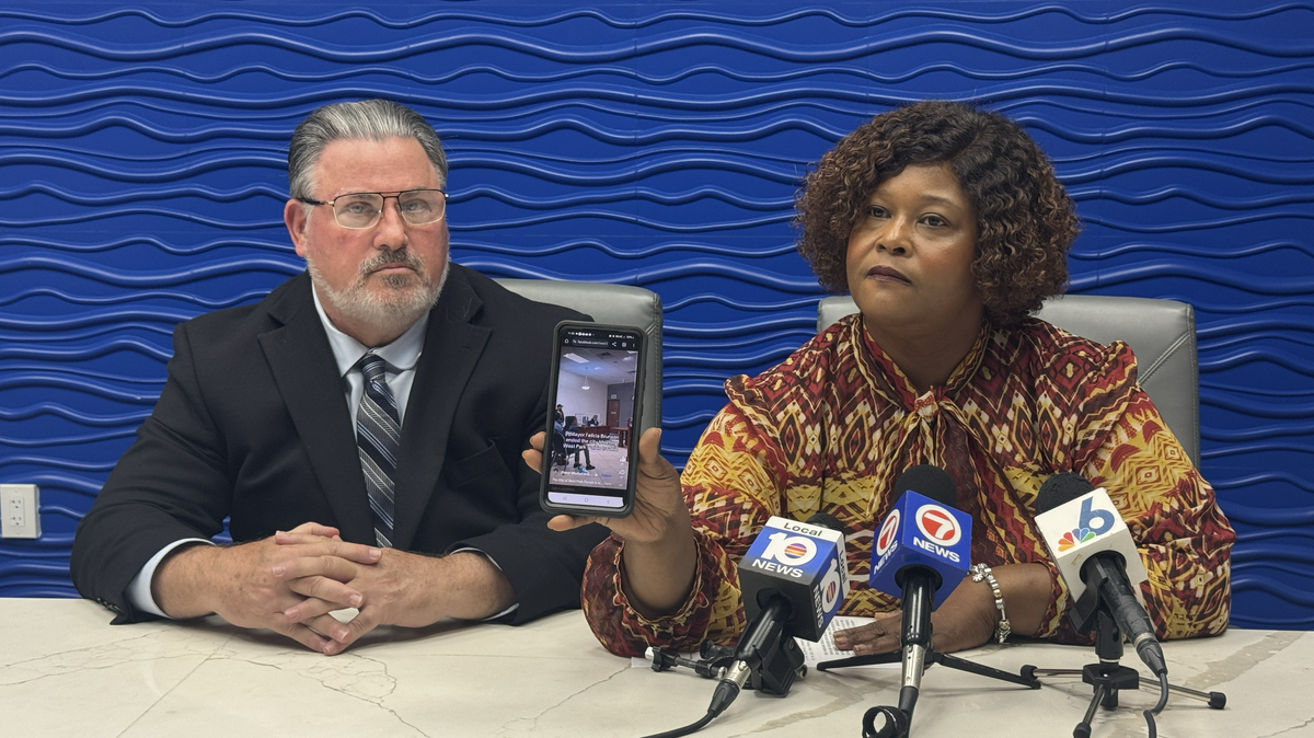 West Park City Commissioner Katrina Touchstone shows reporters at a press conference on Aug. 22 a video of a chaotic city commission meeting in which Mayor Felicia Brunson adjourned early. Touchstone and her attorney Michael Pizzi are suing the city, the mayor, the city clerk and the city manager.