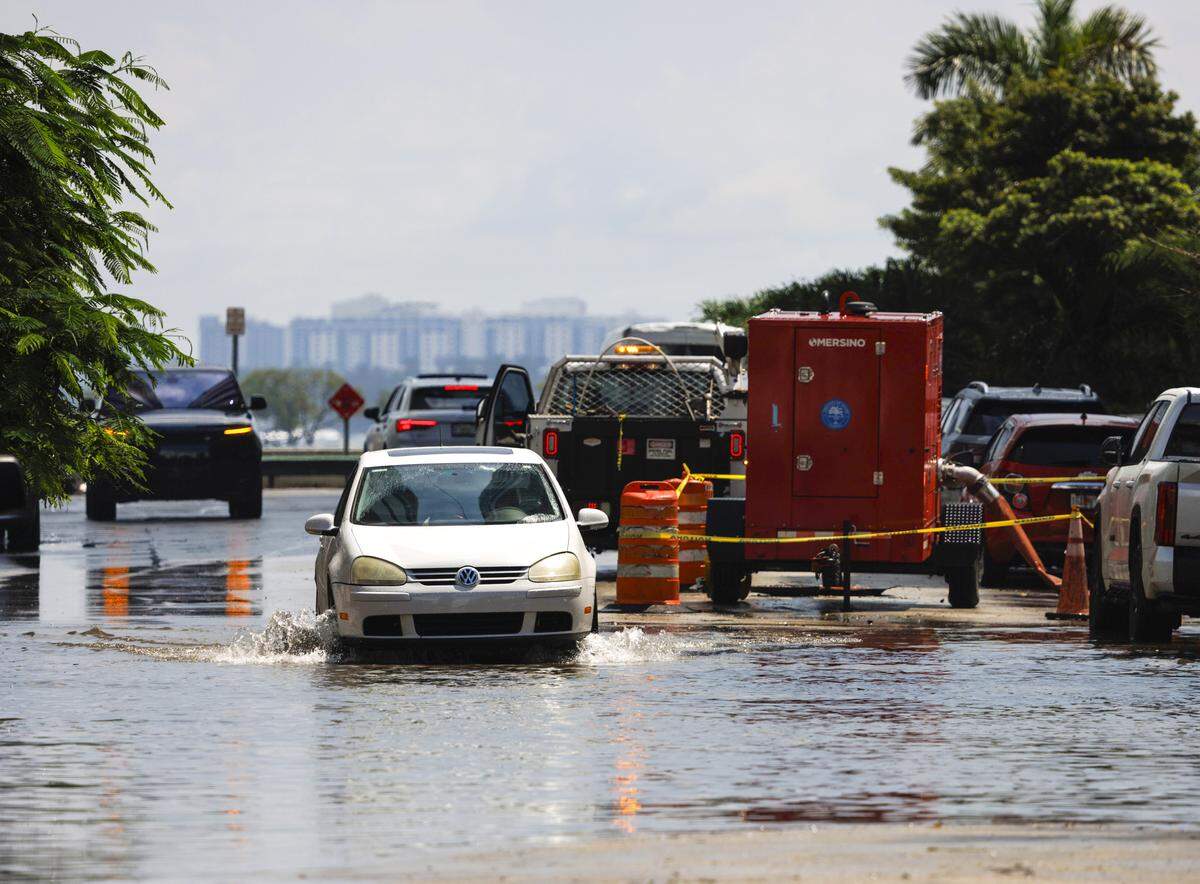 A car drives through the king tide flooding in Edgewater on Tuesday, Sept. 9, 2025 in Miami.