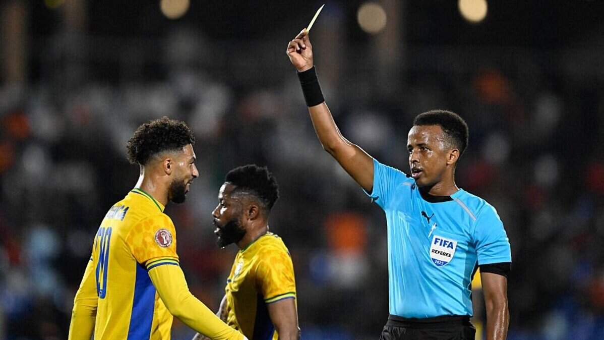 Gabon's forward #20 Denis Bouanga is shown the yellow card by Somali referee Omar Abdulkadir Artan during the Africa Cup of Nations (CAN) Group F football match between Gabon and Ivory Coast at the Grand Stadium in Marrakech on December 31, 2025. (Photo by Khaled DESOUKI / AFP via Getty Images)