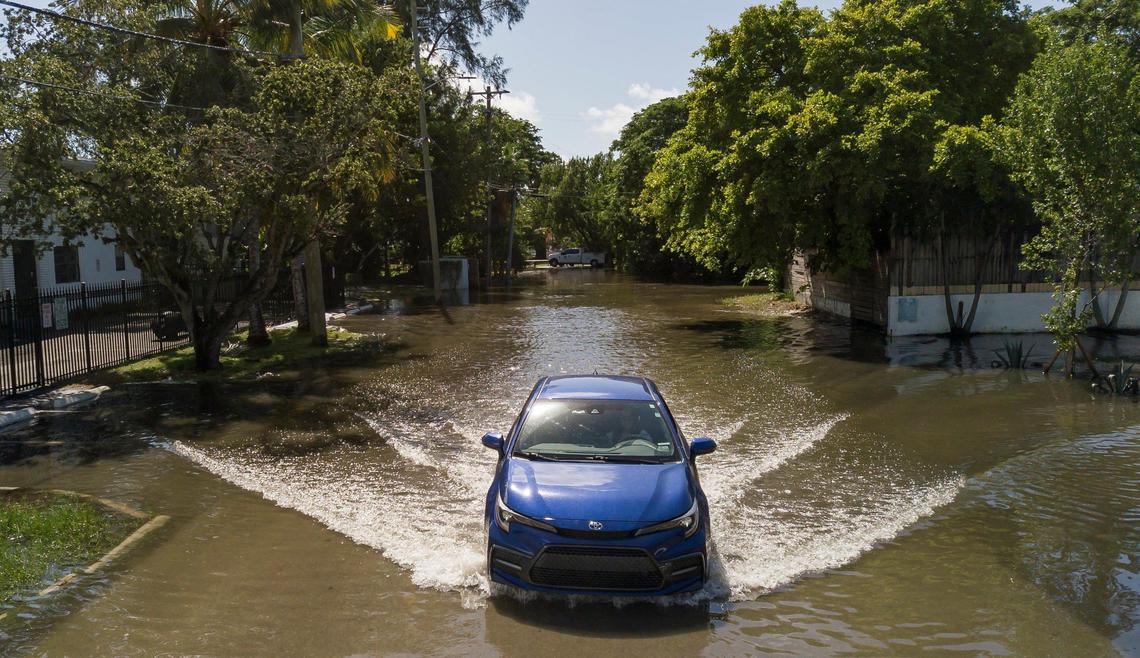 An aerial view of a vehicle making its way through a flooded street near Little River Pocket Park on Monday, Oct. 30, 2023 in Miami, Fla. Monday was the highest king tide of the year for South Florida, flooding streets, driveways and parks.
