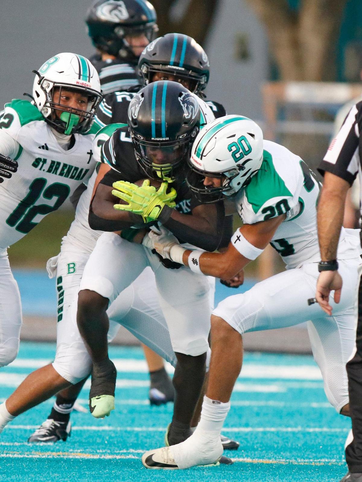 Archbishop McCarthy Mavericks running back Damien Grant (3) tries to break free from St. Brendan Sabres defenders during football game on Thursday, September 5, 2024 at Archbishop McCarthy HS in Southwest Ranches. Andrew Uloza / for Miami Herald