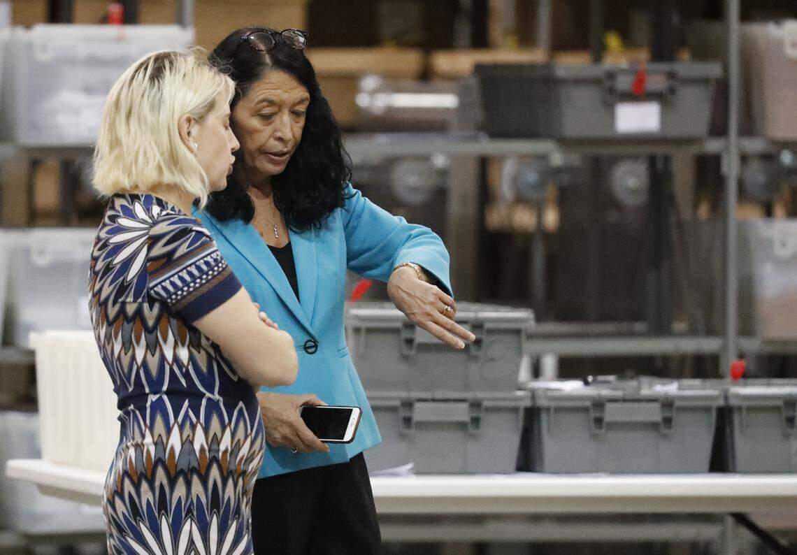 Palm Beach County Supervisor of Elections Susan Bucher checks her watch as she talks to an employee at the elections office during a recount on Thursday, Nov. 15, 2018, in West Palm Beach, Fla.