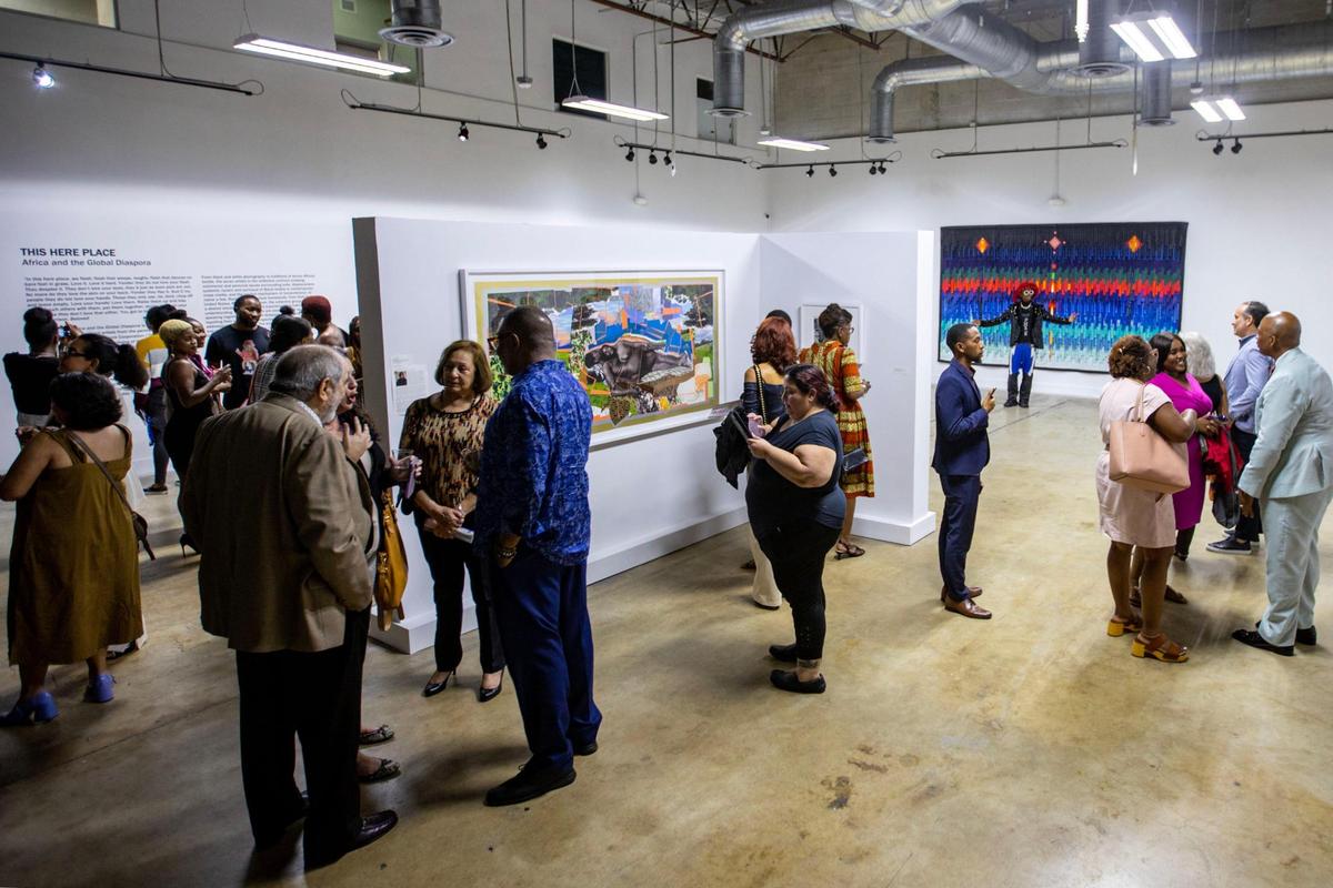 People socialize during the Preview for The Art of Transformation event at The ARC and Logan Building in Opa-locka, Florida, on Wednesday, November 30, 2022. The event is a five-day, three-block Mecca of African and Haitian art fair coinciding with Art Basel Miami Beach 2022 and just one of over 40 ‘exhibits’ part of 2022 Art of Black Miami.