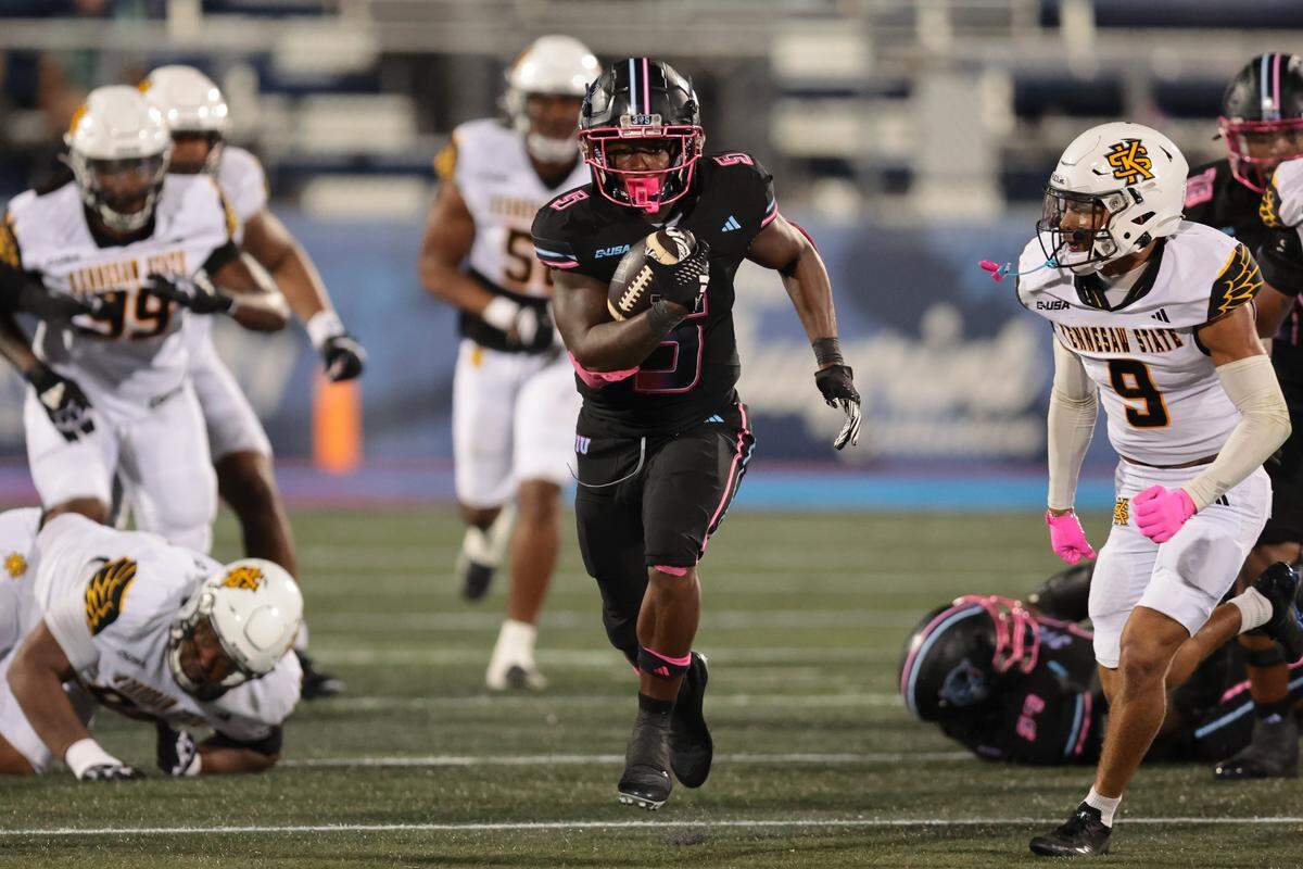 FIU Panthers running back Kejon Owens (5) carries the football against Kennesaw State Owls defensive back Isaac Paul (9) during the third quarter at Pitbull Stadium in Miami, Florida, Tuesday, October 21, 2025.