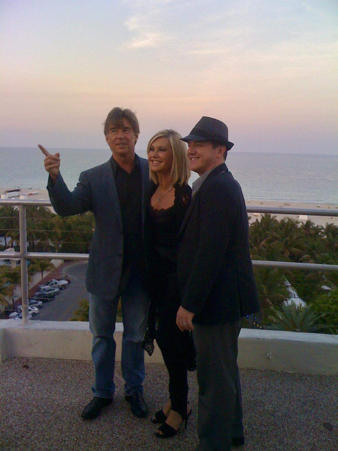 Olivia Newton-John was flanked by two of the most important men in her life at the time of this photo from April 22, 2010. Here, the singer is flanked by her husband John Easterling (left) and her longtime publicist and close friend Michael Caprio, atop The Raleigh Hotel on Miami Beach. Newton-John was there to perform a cancer charity benefit alongside Barry Gibb and Jon Secada later that evening.