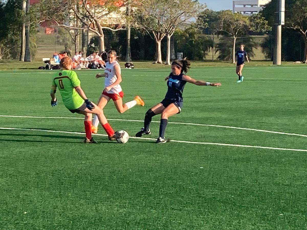 South Broward goalkeeper Casey Carlson and defender Katherine St. Pierre beat Lourdes forward Eva Cova to the ball during Tuesday’s Region 4-6A quarterfinal at Kendall Soccer Park.