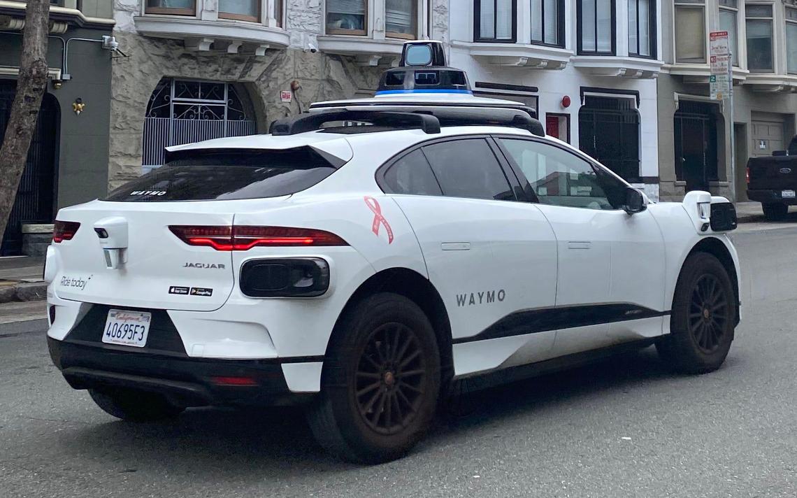 A Waymo self-driving taxi cruises up Pine Street in San Francisco this summer.