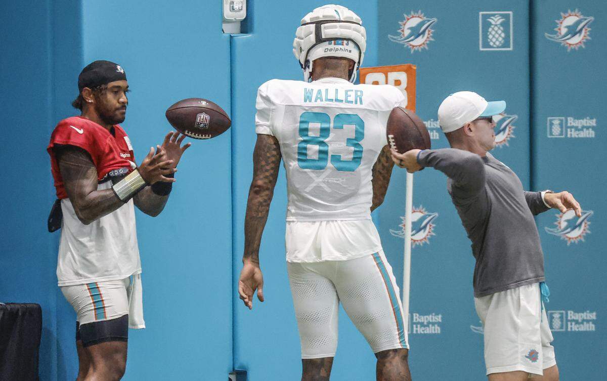 Miami Dolphins tight end Darren Waller (83) tosses the ball to quarterback Tua Tagovailoa (1) during practice at the Miami Dolphins Training Camp in Miami Gardens, Florida, on Wednesday, August 20, 2025.