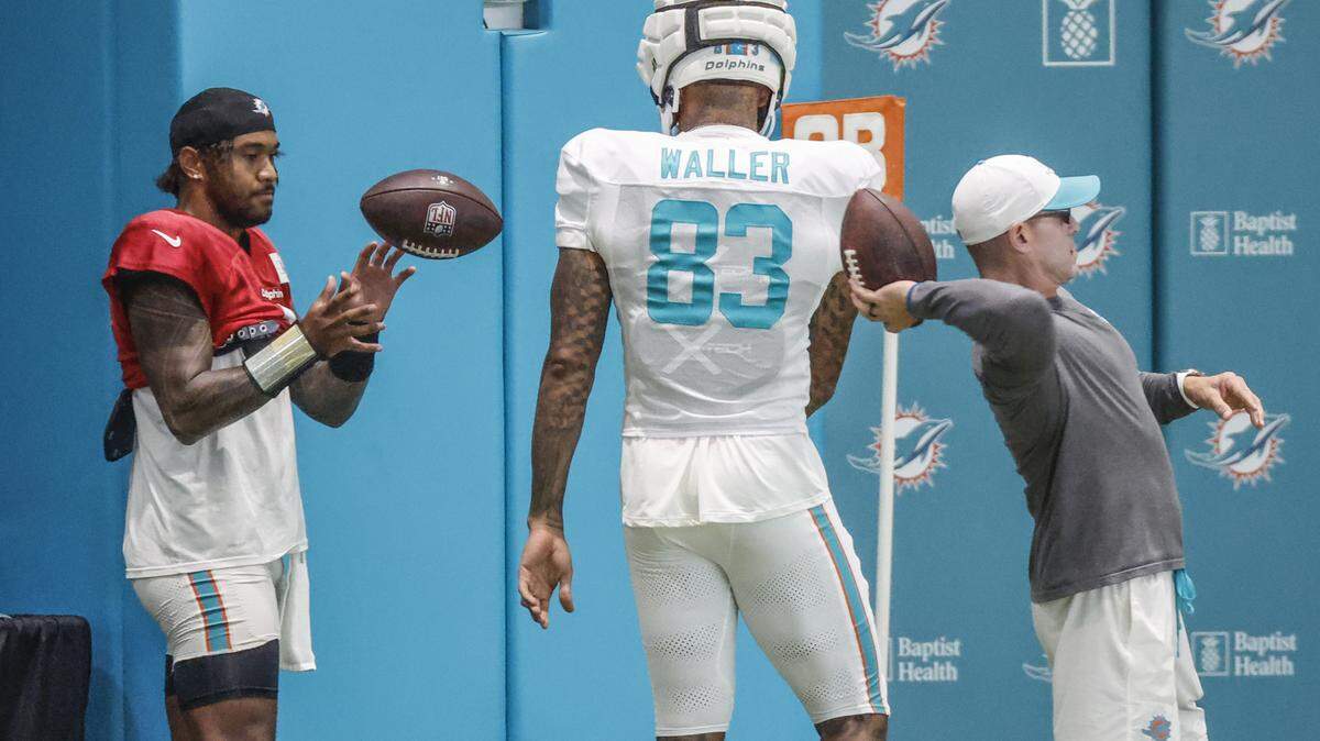 Miami Dolphins tight end Darren Waller (83) tosses the ball to quarterback Tua Tagovailoa (1) during practice at the Miami Dolphins Training Camp in Miami Gardens, Florida, on Wednesday, August 20, 2025.