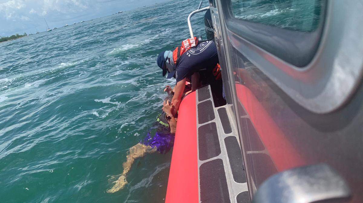 A U.S. Coast Guard crew member rescues a woman from the water off Key West Thursday afternoon, Aug. 6, 2021.