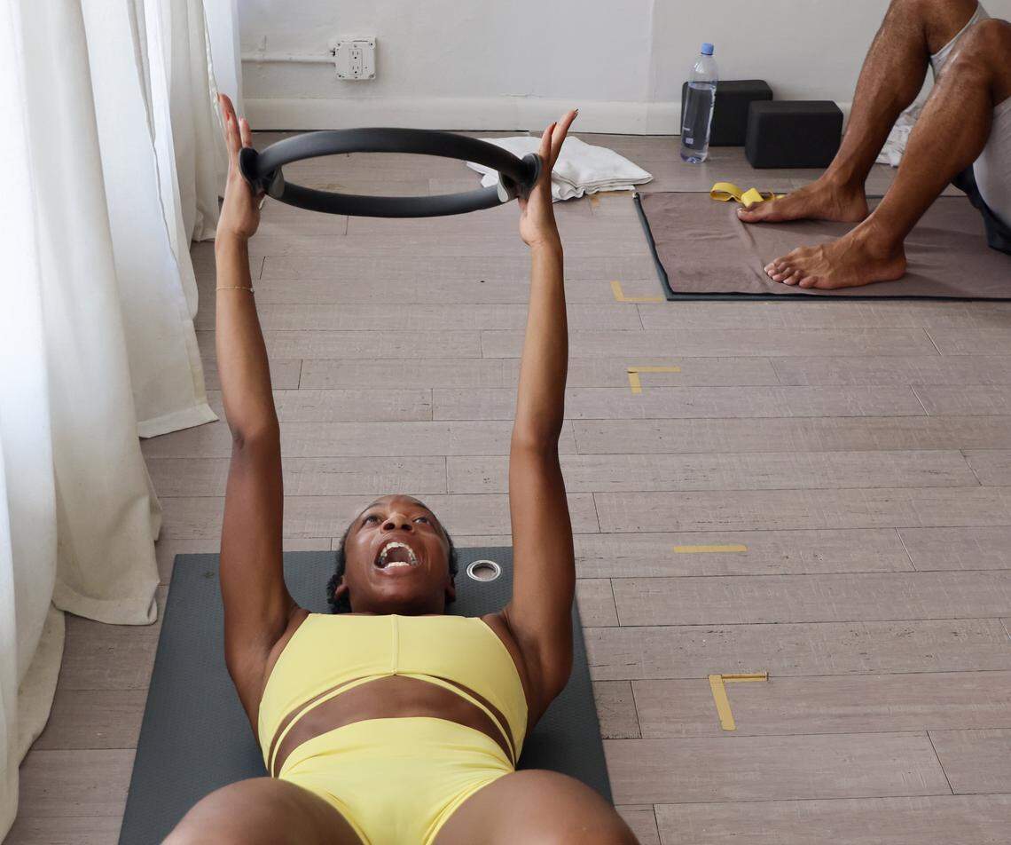 Navy vet and Pilates instructor Shay Williams, left, leads the class in poses using a ring at Hanu Yoga in Miami Beach, Florida on Sunday, November 9, 2025.