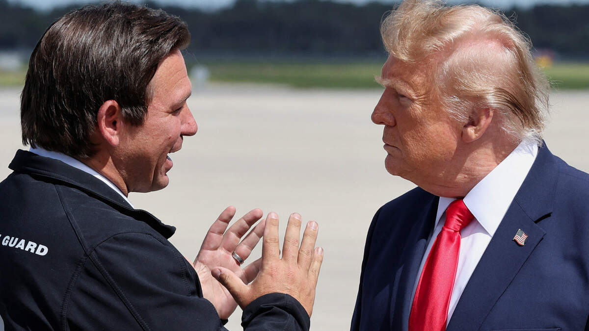 Florida Governor Ron DeSantis speaks with US President Donald Trump as he arrives at Southwest Florida International Airport