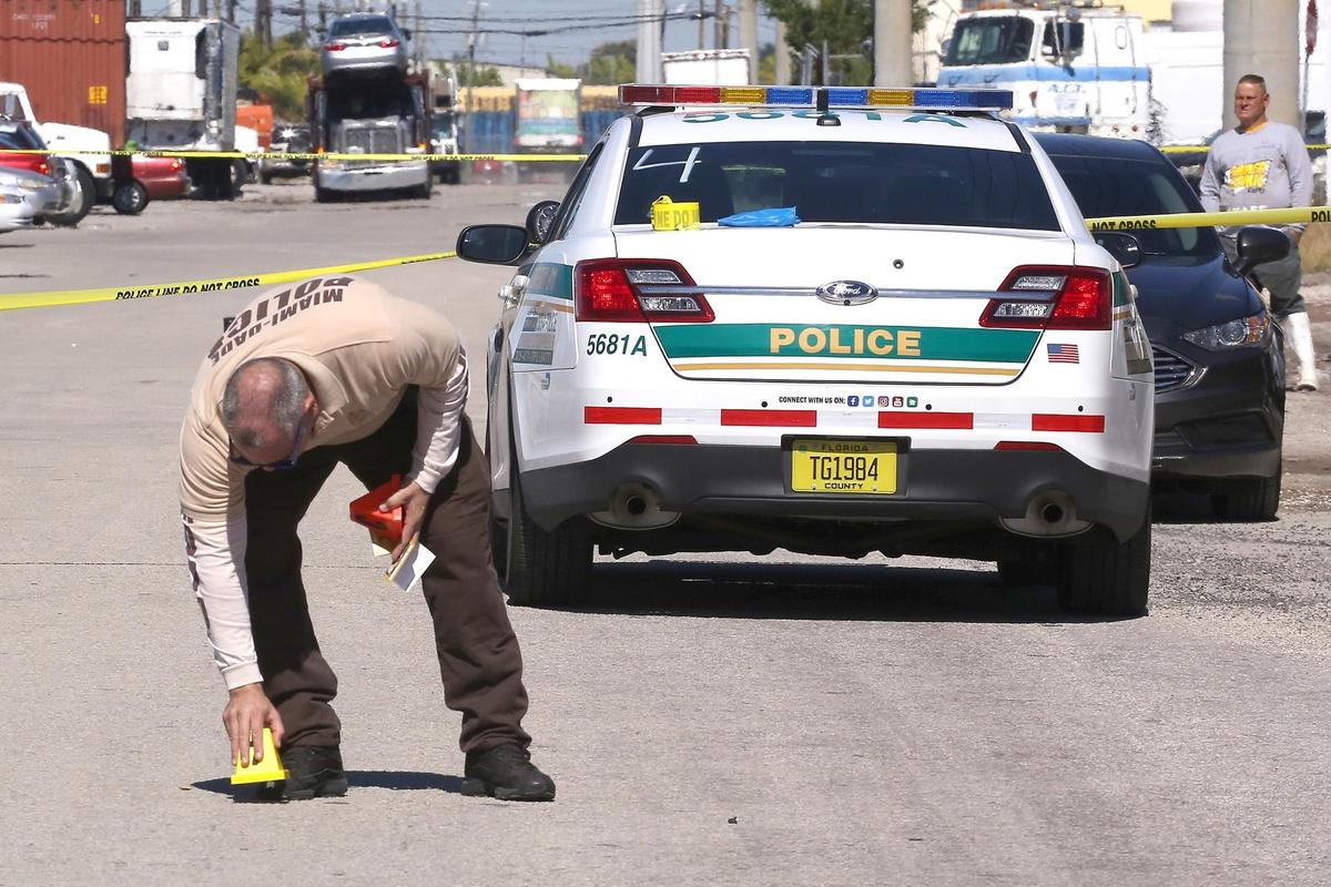 A crime scene investigator places shell casing markers at the crime scene at 6540 NW 35th Ave. Approximately at 10 a.m. Tuesday, Jan. 29, 2019, a subject approached two people working a food truck and demanded their money. The workers gave him their money, and then one of the food truck workers shot the suspect in the leg as he was running away.