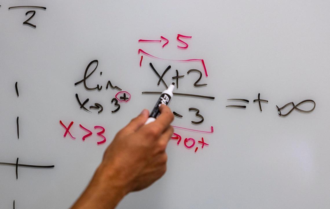 Learning Assistant Juan Ignacio Sanchez Quintana, center, works with a student in Calculus I class. Miami, Florida, August 31, 2023
