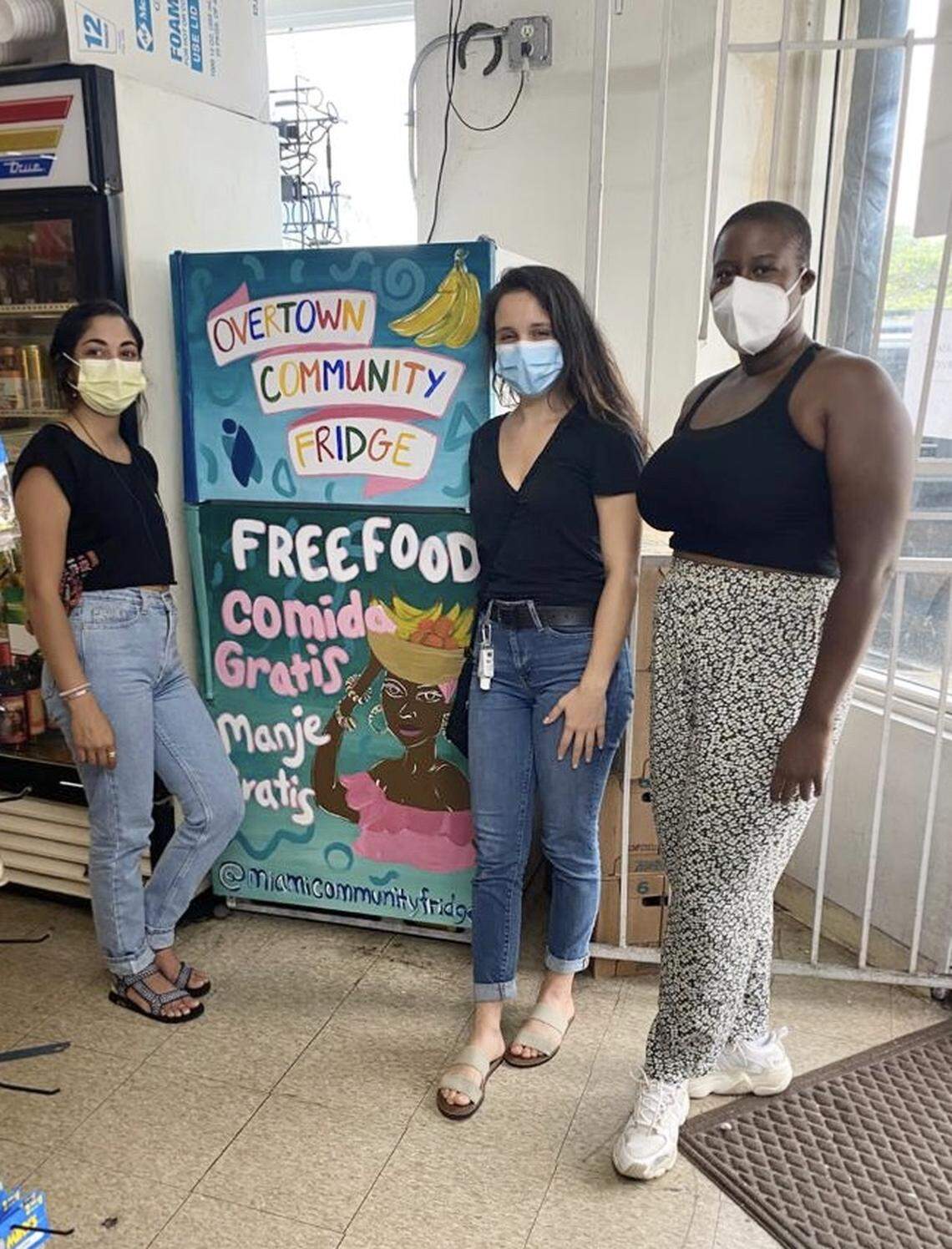 From left, artist Natalie Galindo, who painted the refrigerator, helped unveil it with Buddy System MIA volunteers Vanessa Gomez and Fania Celestin, who helped place the fridge in Overtown’s Habra Food Store.