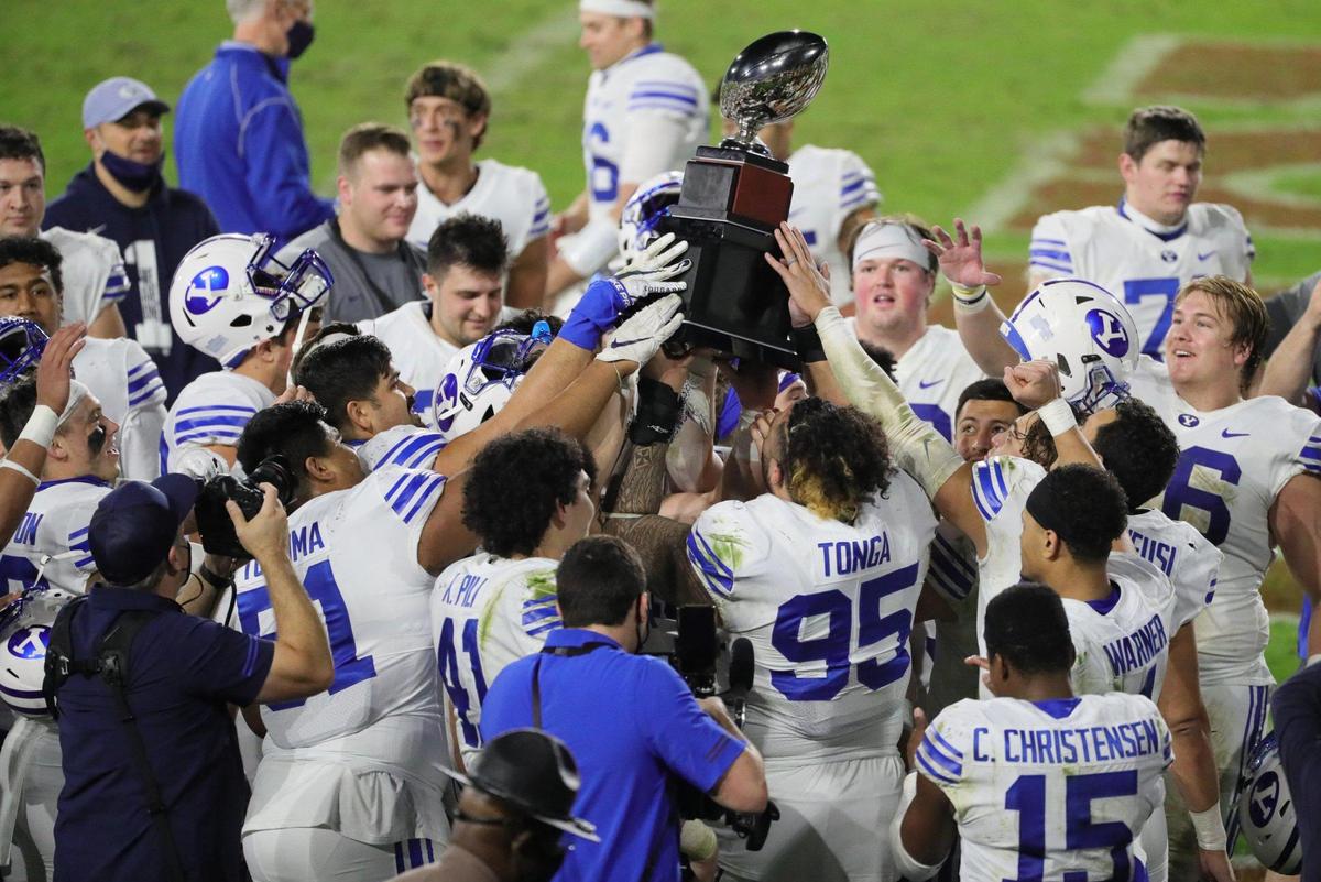Brigham Young Cougars players hold the championship trophy after defeating UCF Knights in the Boca Raton Bowl 2020 at FAU Stadium in Boca Raton on Tuesday, December 22, 2020.
